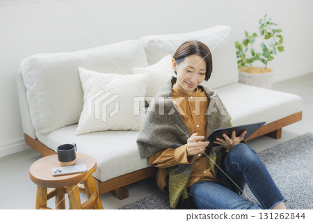 A woman using a tablet in the living room A woman using a tablet in the living room 131262844