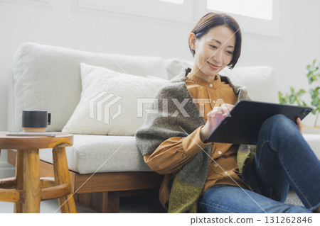 A woman using a tablet in the living room A woman using a tablet in the living room 131262846