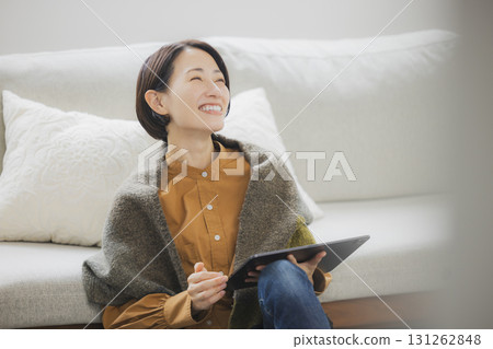 A woman using a tablet in the living room A woman using a tablet in the living room 131262848