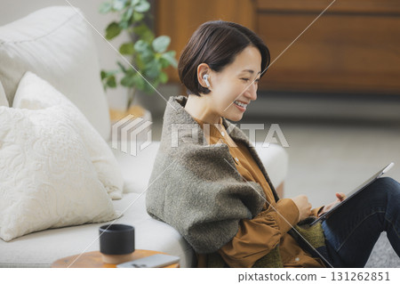 A woman using a tablet in the living room A woman using a tablet in the living room 131262851