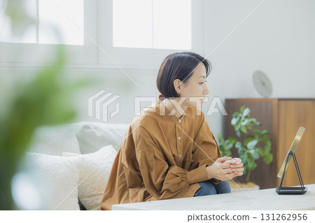 A woman looking in the mirror in the living room A woman looking in the mirror in the living room 131262956