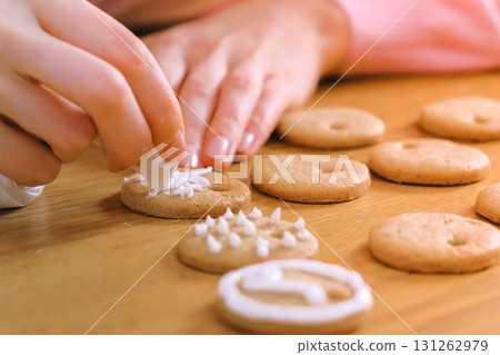 Woman's hands decorate christmas cookies with sugar sweet icing. Woman's hands decorate christmas cookies with sugar sweet icing. 131262979