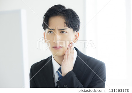 A man in a suit looking in the mirror A man in a suit looking in the mirror 131263178