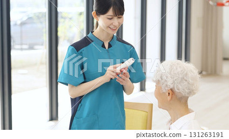 Asian caregiver taking the temperature of an elderly person 131263191