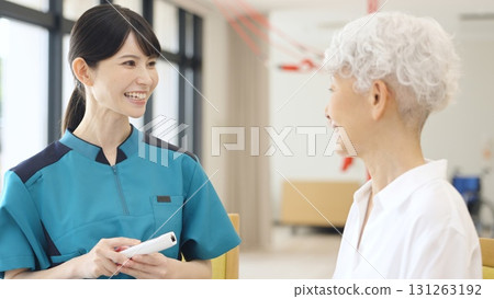 Asian caregiver taking the temperature of an elderly person 131263192