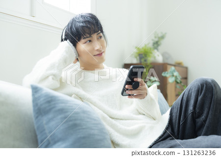 A man listening to music in the living room A man listening to music in the living room 131263236