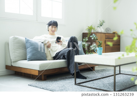 A man listening to music in the living room A man listening to music in the living room 131263239