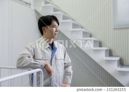 A man in work clothes pushing a cart in a warehouse A man in work clothes pushing a cart in a warehouse 131263255