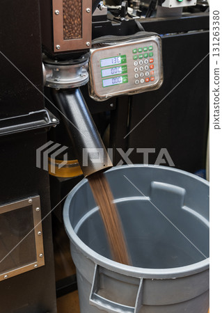 Roasted coffee beans just after roasting are fast poured from industrial roaster Roasted coffee beans just after roasting are fast poured from industrial roaster 131263380