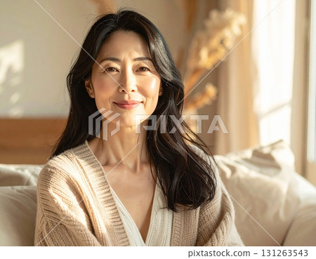 A Japanese woman (50s) smiling gently in natural light, long hair, natural portrait 131263543