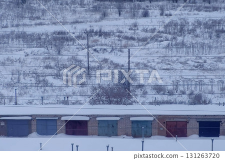 Number of garages for cars near the power line in the snow in winter. Number of garages for cars near the power line in the snow in winter. 131263720