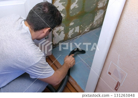 Man vacuuming construction garbage after repairing works in lavatory room. Man vacuuming construction garbage after repairing works in lavatory room. 131263848