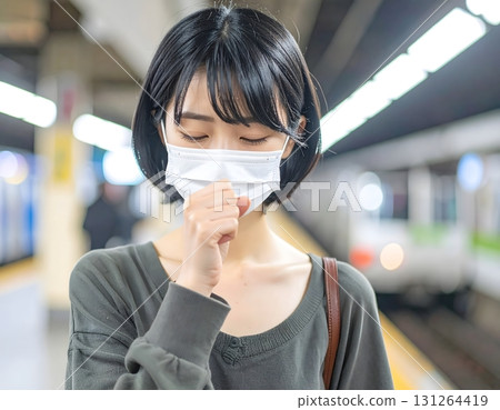 A masked woman coughing with the flu 131264419