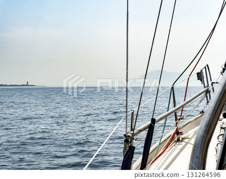 Tarifa lighthouse and the silhouette of african mountains seen from a sailboat Tarifa lighthouse and the silhouette of african mountains seen from a sailboat 131264596