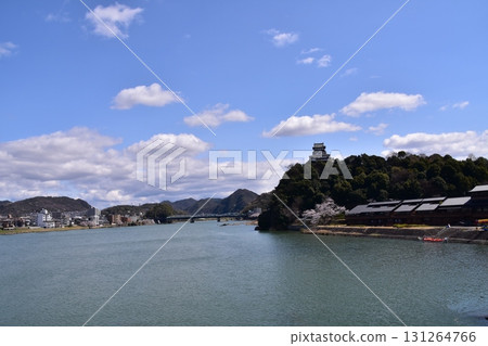 Inuyama City, Aichi Prefecture, Japan. Inuyama Castle and cherry blossoms in full bloom in spring. A sightseeing boat on the Kiso River with beautiful blue skies. Tourists boarding the boat. Inuyama City, Aichi Prefecture, Japan. Inuyama Castle and cherry blossoms in full bloom in spring. A sightseeing boat on the Kiso River with beautiful blue skies. Tourists boarding the boat. 131264766