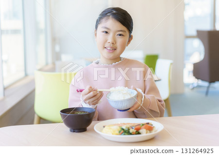 An elementary school girl eating Japanese food at a restaurant. Photo courtesy of Tokyo Electronics College, Denpa Gakuen School Corporation. An elementary school girl eating Japanese food at a restaurant. Photo courtesy of Tokyo Electronics College, Denpa Gakuen School Corporation. 131264925