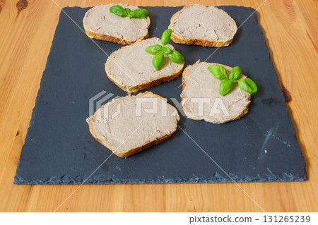 Sandwiches with pate on a slate board on wooden table 131265239