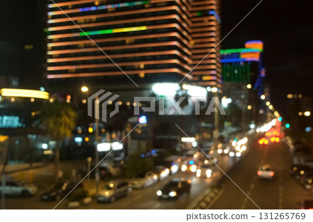 Blurred night seascape with moving cars on highway near illuminated buildings. 131265769