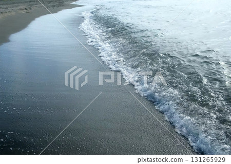 Long quiet waves washing sea shore with sandy sand volcanic beach. Long quiet waves washing sea shore with sandy sand volcanic beach. 131265929