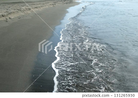 Gentle waves washing sea shore with sandy sand volcanic beach. Gentle waves washing sea shore with sandy sand volcanic beach. 131265930