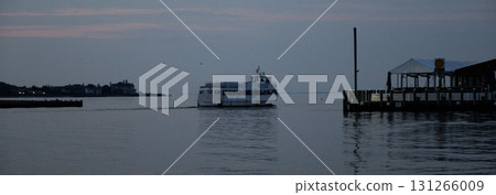 Early Morning Fire Island Ferry moving Across Calm Water Near Coastal Town 131266009