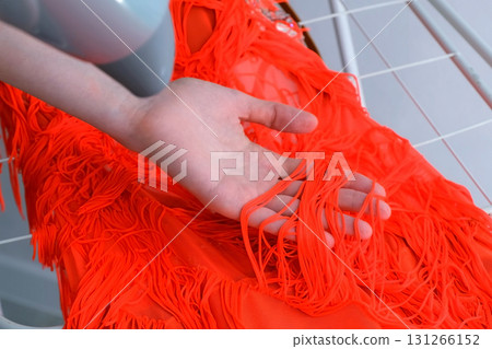 Woman is drying dress for sports ballroom dancing using hair dryer, closeup. 131266152