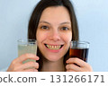 Young woman with yellow bad teeth keeping lemonade in hands and smiling. 131266171