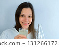 Young woman with yellow bad teeth pouring lemonade in glass and smiling. 131266172