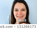 Young woman with yellow bad teeth pouring lemonade in glass and smiling. 131266173