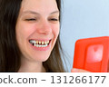 Young smiling woman with yellow bad teeth calling by video on mobile phone. 131266177