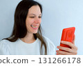 Young smiling woman with yellow bad teeth calling by video on mobile phone. 131266178