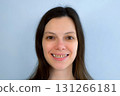 Portrait of young woman with yellow bad teeth is smiling and looking at camera. 131266181