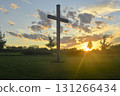 A large Christian cross in the scenery of a landscape. A Christian cross lighted by the setting sun. The concept of religion and Christianity. 131266434