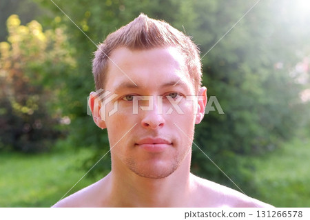 Portrait of muscular sportsman in city park after training looking at camera. 131266578