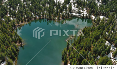 Mountain lake with snow mountains and green forest Mountain lake with snow mountains and green forest 131266717