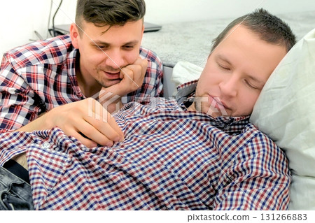 Men gay lie down together and flirt each other. 131266883