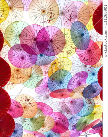 Colorful Chinese umbrellas hanging together creating a beautiful, vibrant overhead display. 131266901