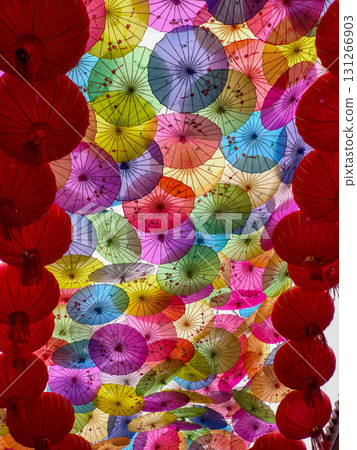 Colorful Chinese umbrellas hanging together creating a beautiful, vibrant overhead display. Colorful Chinese umbrellas hanging together creating a beautiful, vibrant overhead display. 131266903