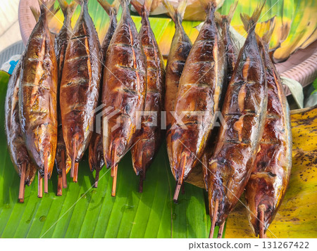 Smoked fish skewers on a banana leaf, a popular street food delicacy in Surabaya, Indonesia. Golden-brown and appetizing. 131267422