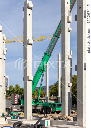 Extra heavy weight load mobile boom crane working modern city construction site with many concrete pillars blue sky background. Telescopic boom lifting equipment rental service. Industrial machinery 131267445