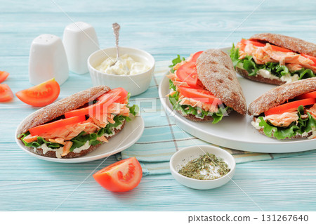 rye bread sandwiches with grilled salmon, veggies 131267640