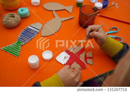 Craft a fish model from cardboard, thread, and paint, with detailed steps, on an orange background. Craft a fish model from cardboard, thread, and paint, with detailed steps, on an orange background. 131267718