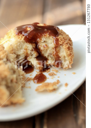 A fluffy Hokkaido potato croquette cut in half and topped with sauce 131267780