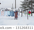 Elderly Lady hang out laundry Winter 131268311