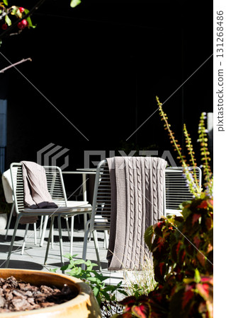 Cozy outdoor cafe with eco friendly furniture, offering perfect space to enjoy meals while surrounded by nature. Ideal for dining in sustainable, relaxed and green urban environment 131268486