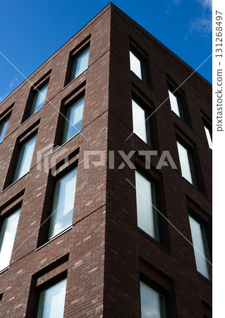 Sharp, angular view of modern brick residential building. The symmetrical design and clean lines highlight the architectural style and functionality of contemporary urban living 131268497