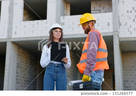 Construction engineers inspecting building progress at construction site Construction engineers inspecting building progress at construction site 131268577