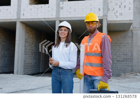 Construction workers wearing safety gear at building site Construction workers wearing safety gear at building site 131268578