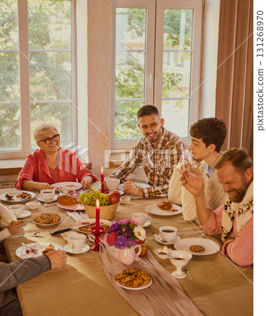 Multigenerational family enjoying conversation at festive dining table Multigenerational family enjoying conversation at festive dining table 131268970