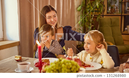 Family smiling and sharing homemade pie at festive decorated table Family smiling and sharing homemade pie at festive decorated table 131268980